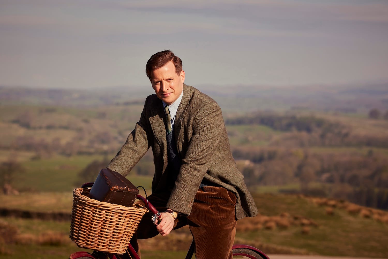 James Herriot (Nicholas Ralph) on a bicycle, for once not appreciating the gorgeous scenery