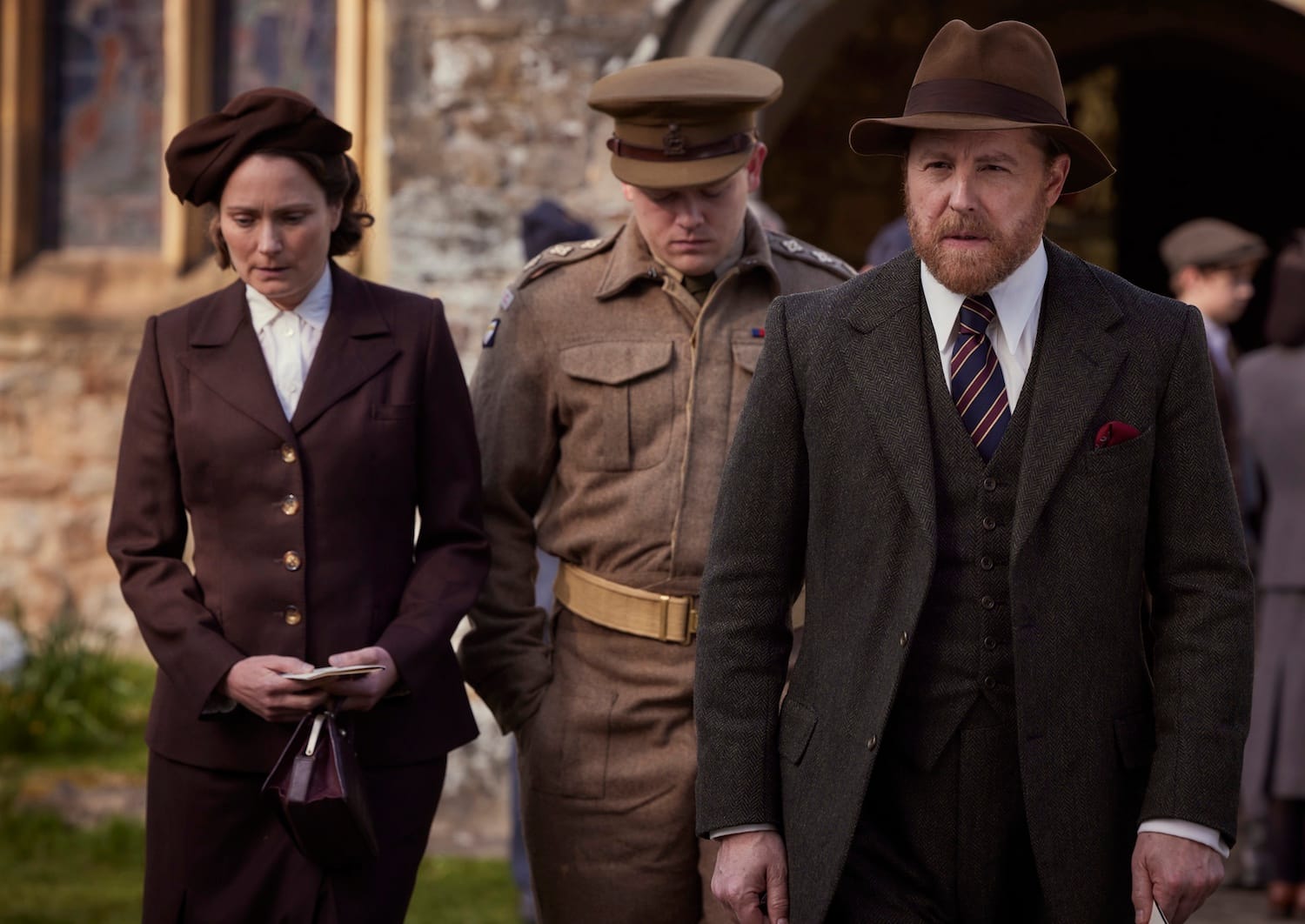 In a somber mood, leaving the church after the memorial service, Mrs. Hall (Anna Madeley), Tristan Farnon (Callum Woodhouse) and Siegfried Farnon (Samuel West)