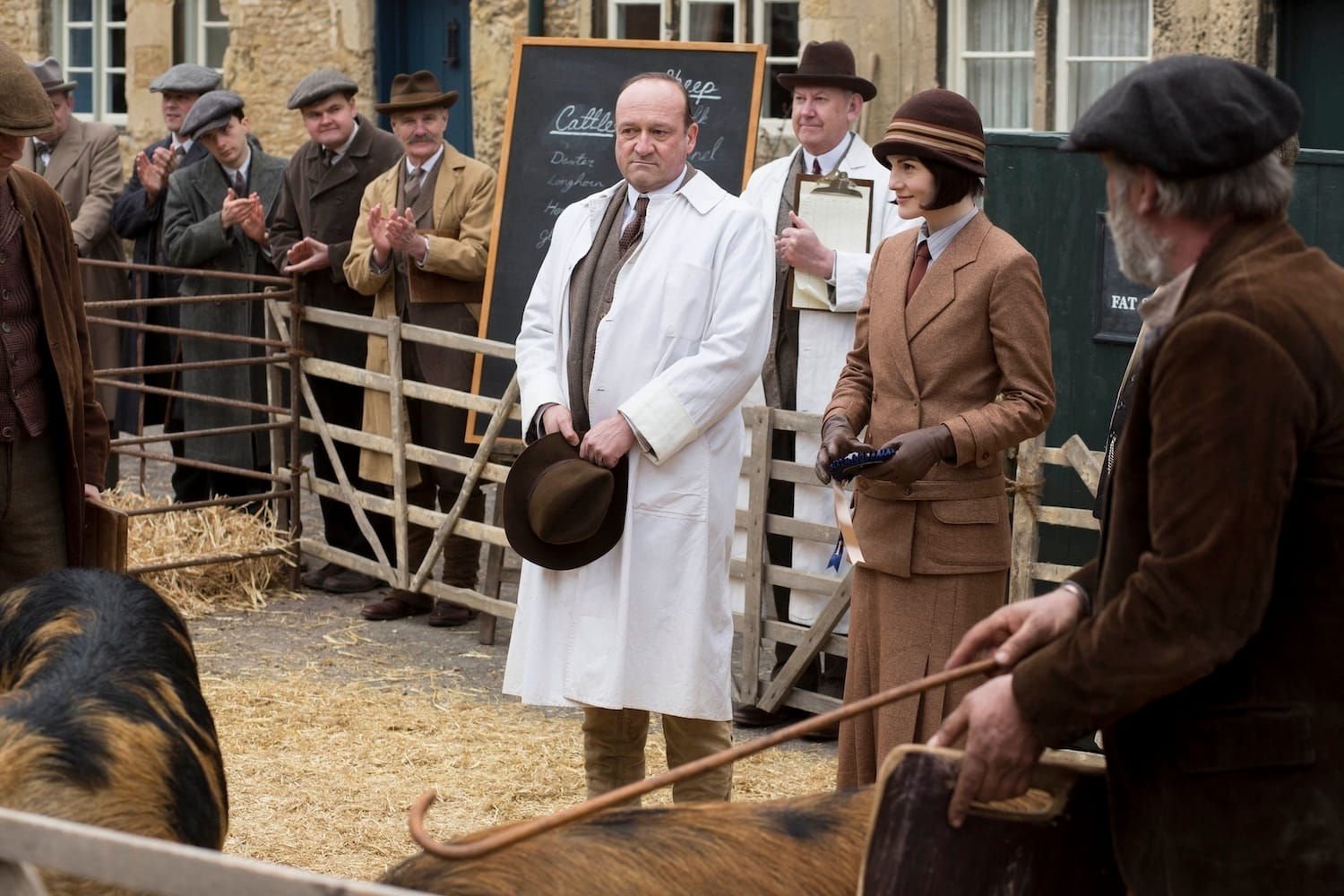 Lady Mary (Michelle Dockery) shows her pigs, surrounded by all-male contest officials and spectators.