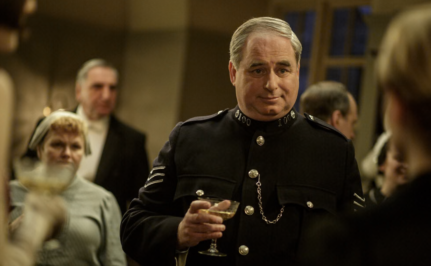 Police Sergeant Willis (Howard Ward) celebrates with the downstairs staff.