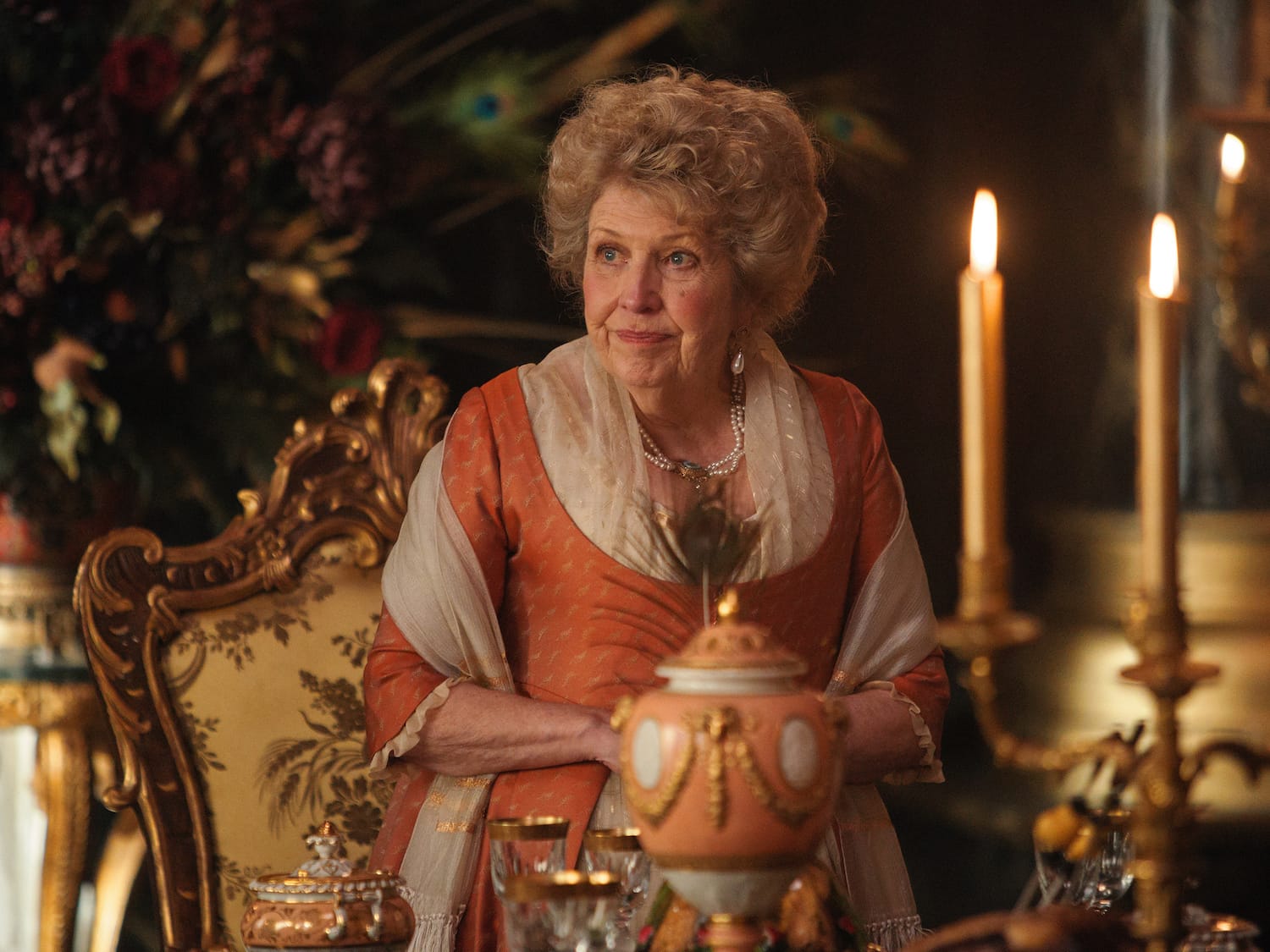 Lady Denham (Anne Reid) with the container that holds a pineapple.