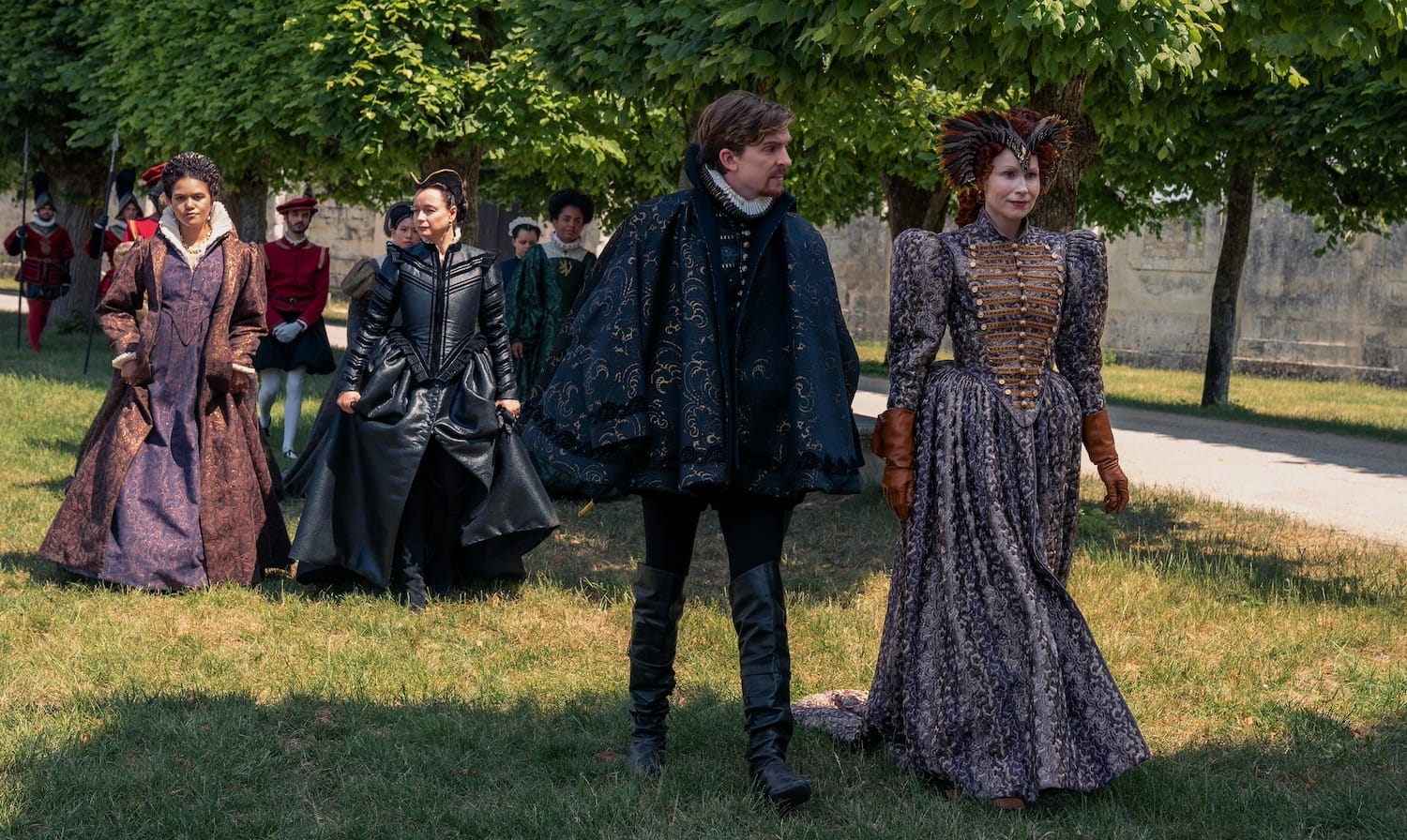King Charles IX (Bill Milner) and Queen Elizabeth I in conversation together, followed by Catherine (Samantha Morton) and Rahima (Emma McDonald).