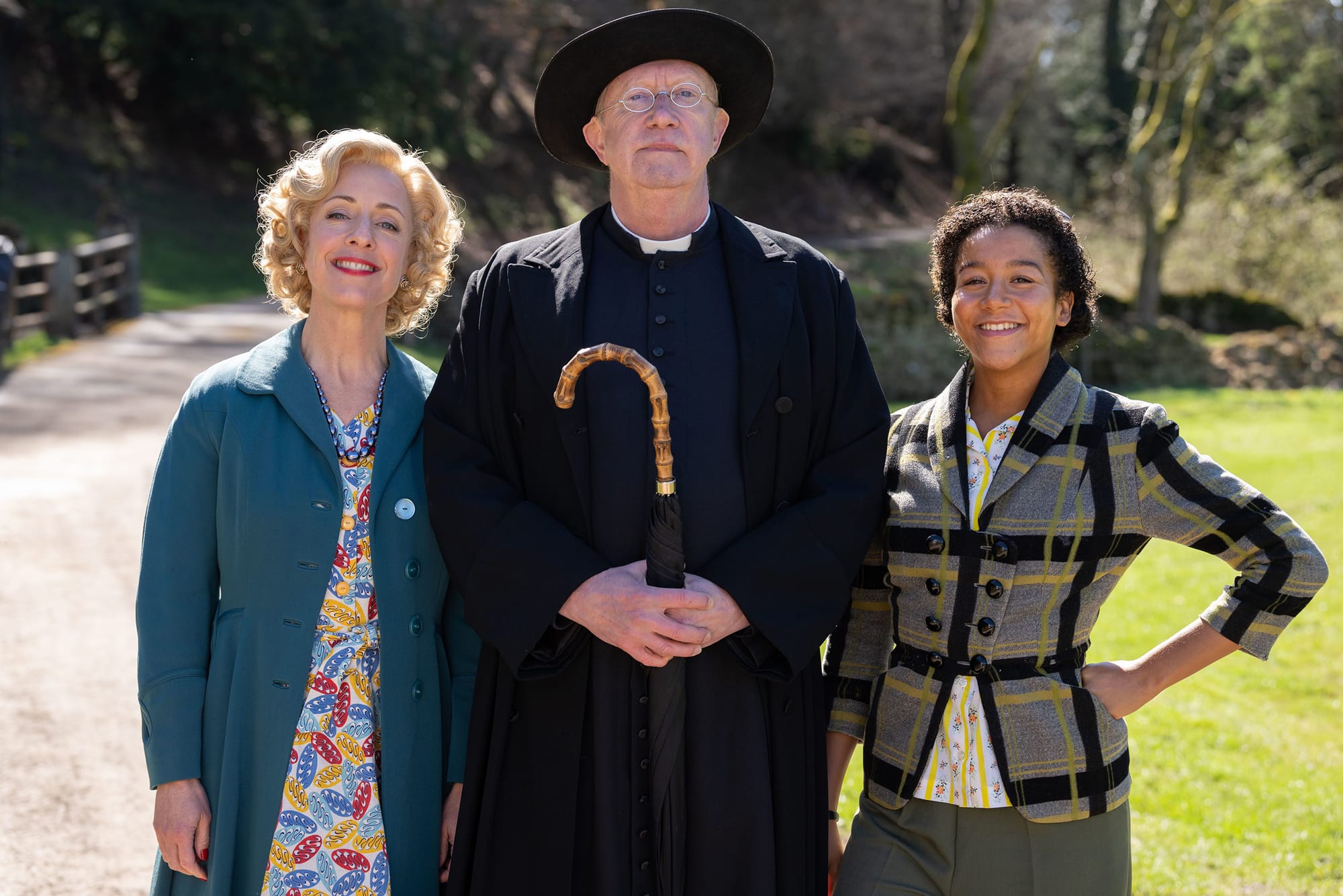 Claudie Blakley as Mrs Devine, Mark Williams as Father Brown, and Ruby-May Martinwood as Brenda Palmer in 'Father Brown' Season 12